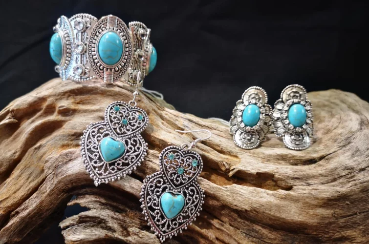 boucles d'oreilles fantaisie blanches et bleues posées sur une écorce d'arbre